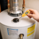 Plumber examining a residential water heater for lifespan and condition