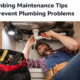 Plumber tightening kitchen sink pipe during plumbing maintenance to prevent leaks and common plumbing problems