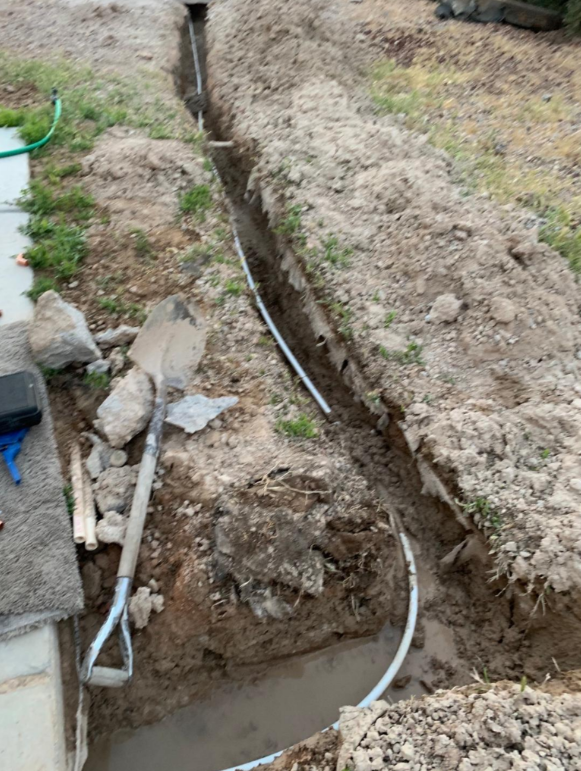 Long trench for main water line replacement in Las Vegas NV with exposed underground piping