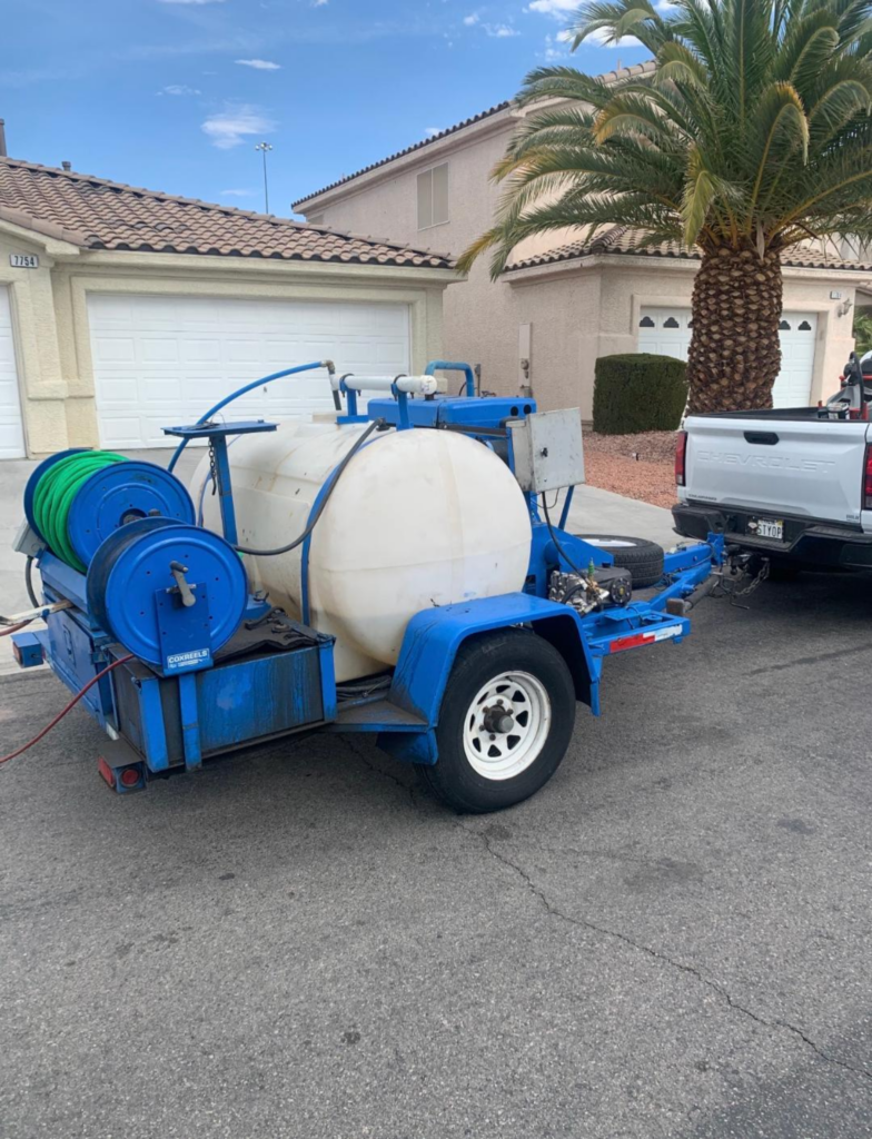 Hydro jetting trailer with large water tank and hose reels parked in residential Las Vegas neighborhood