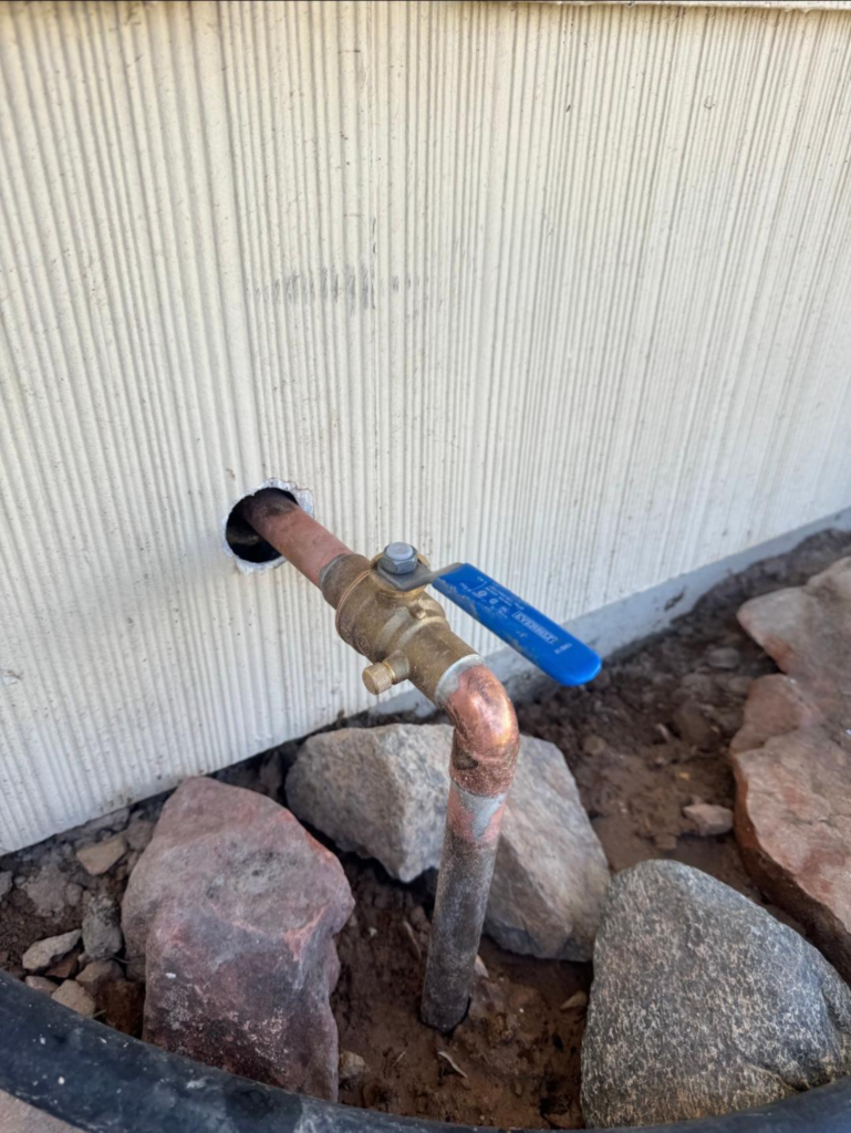 Exterior water supply line with copper pipe and shutoff valve installed outside Las Vegas home