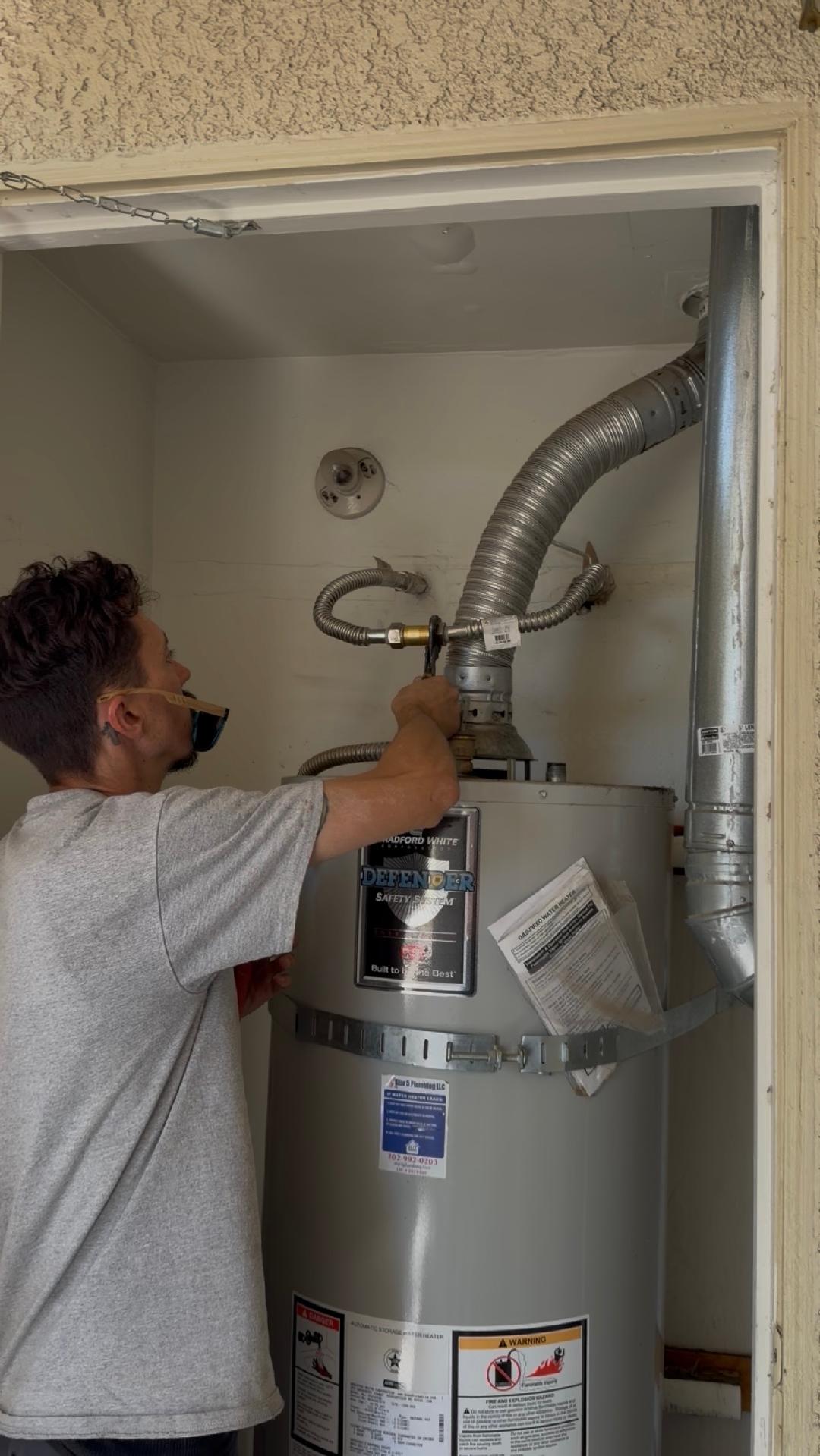 Plumbing Repair Experts technician connecting gas line and exhaust flue on water heater in Las Vegas, NV